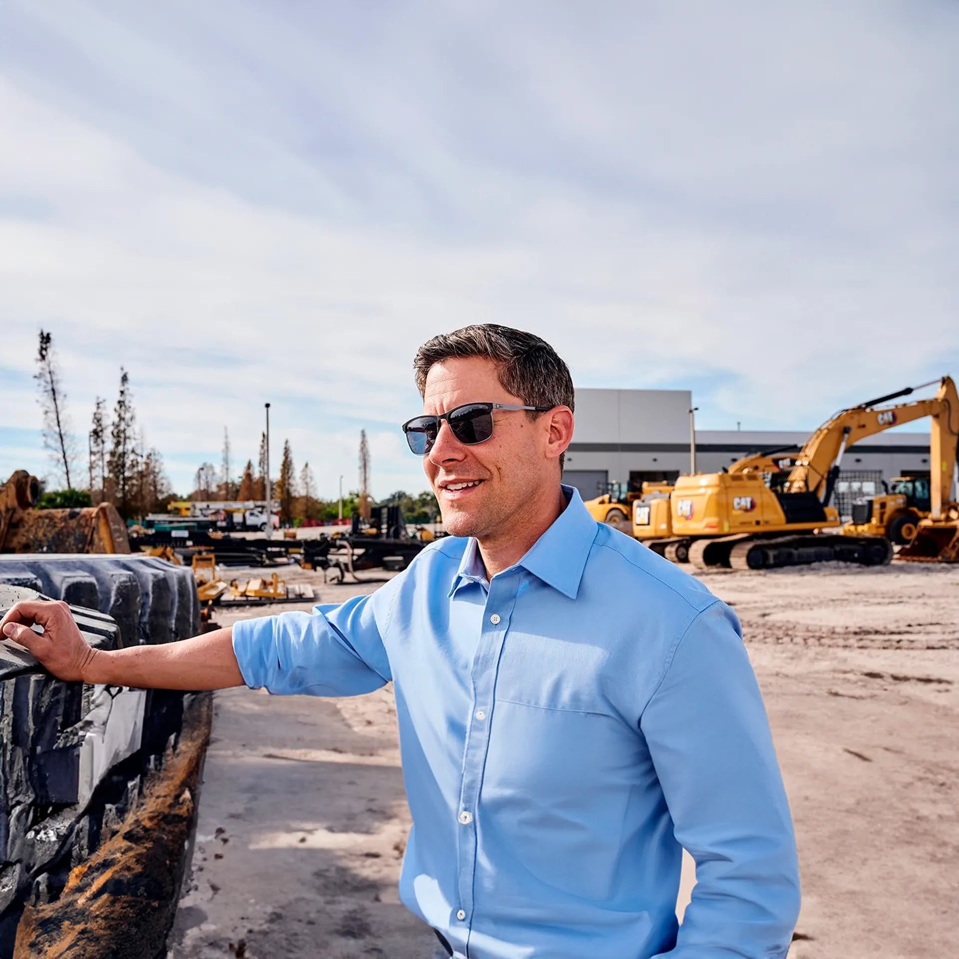 Hombre sonriendo usando lentes de sol marca CAT